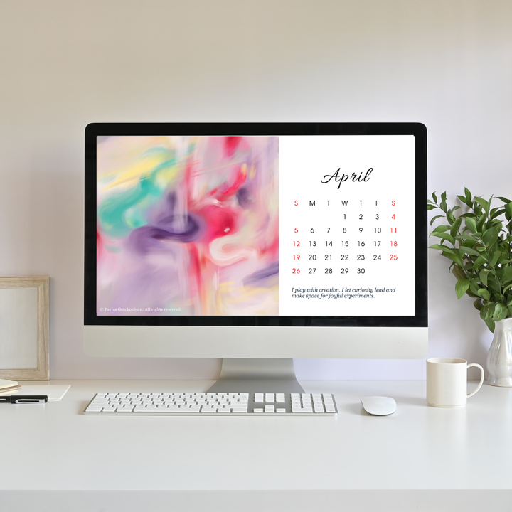 Computer monitor displaying an April calendar on a desk with a plant and mug.