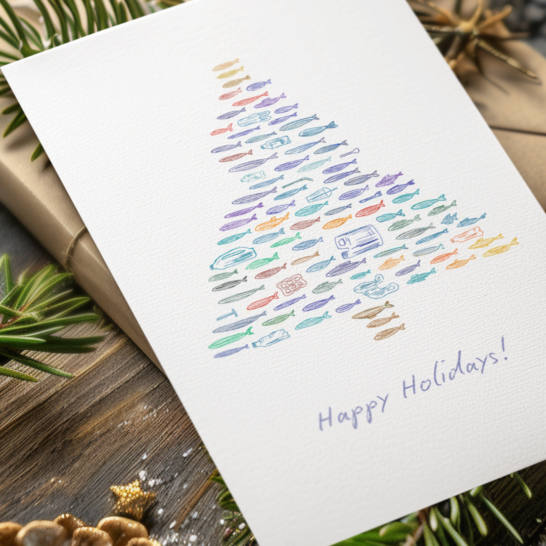 Holiday card with colorful tree design on a wooden surface with Christmas decorations